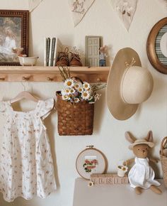 there is a basket with flowers on the wall next to a hat and other items