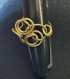 This exquisite handmade brass wire ring features a mesmerizing swirled design that will add a touch of elegance to any outfit. Crafted with care and attention to detail, this unique piece is perfect for those who appreciate artistry in their jewelry. Each ring is carefully handmade, ensuring a one-of-a-kind look that is sure to turn heads. Make a statement with this beautiful brass wire ring that is as unique as you are.  Nonadjustable.  Size 7.  Thank you for visiting Studio729! I welcome your business and appreciate my customers. I offer combined shipping for all multi-item orders. To see all of my handmade jewelry, just click here: http://www.etsy.com/shop/studio729 If vintage jewelry, antiques and collectibles are more to your liking, please check my other Etsy website at http://www.et Unique Gold Wire Wrapped Ring, Artistic Gold Spiral Jewelry, Bohemian Gold Swirl Jewelry, Gold Wire Wrapped Swirl Jewelry, Gold Swirl Wire Wrapped Jewelry, Handmade Swirl Shaped Gold Jewelry, Handmade Gold Swirl Jewelry, Gold Swirl-shaped Handmade Jewelry, Gold Swirl Handmade Jewelry