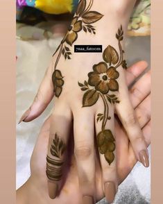 the hand is decorated with flowers and leaves