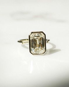 a diamond ring sitting on top of a white surface