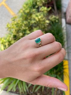 "Shower her with love with this Colombian emerald and diamond three stone ring. An extraordinary custom-created ring. Designed and created by our own master jeweler, \"Robinson\". Dexterously handcrafted in gleaming 18K white gold, this ring features a 1.70-carat natural Colombian emerald - emerald cut from the famous Muzo mines. Set in a secure prong setting for extra protection, this extraordinary emerald has a stunning dark green color, tone, and an incandescent glow. Delicately cut with prop Luxury Three-stone Emerald Ring For Anniversary, Luxury Three Stone Emerald Ring For Anniversary, Fine Jewelry Three Stone Rings For Proposal, Green Three Stone Baguette Cut Ring, Green Baguette Cut Three Stone Rings, Emerald Diamond Ring For Proposal, Emerald Three Stone Ring With Diamonds, Three-stone Fine Jewelry For Proposal, Fine Jewelry Three Stone Baguette Cut Ring