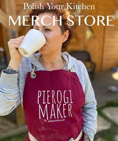 a woman in an apron drinking from a cup with the words polish your kitchen merch store on it