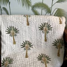 a bed with palm trees on it next to a wall