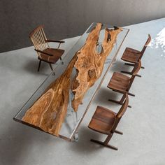 a table made out of wood and glass with chairs around it on concrete flooring