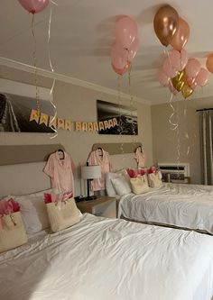 two beds in a room with balloons hanging from the ceiling