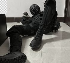 a pair of black boots sitting on top of a floor next to a tv monitor