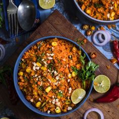 a bowl filled with carrots and corn next to other food on a cutting board