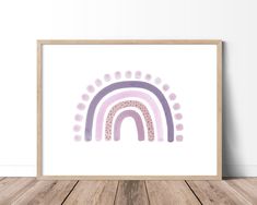 an art print with a rainbow in the middle on a wooden floor next to a white wall