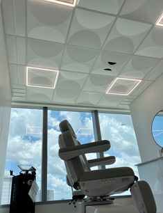 an office chair in front of a window with a view of the sky and clouds