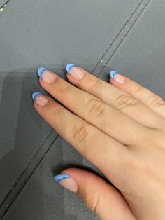 a woman's hand with blue nail polish on it