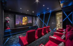 a home theater with red seats and large screen