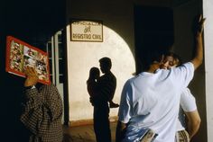 two men are standing in front of a building and one is holding up a sign