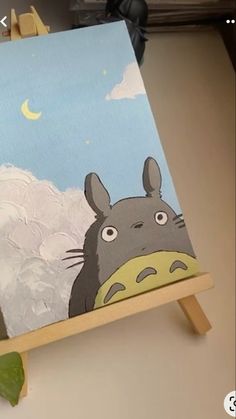 an easel with a painting of totoro on it