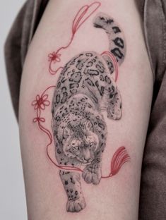 a woman's arm with a tattoo on it that has an image of a leopard