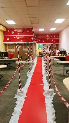 an office decorated for christmas with red and white candy canes on the floor, along with decorations