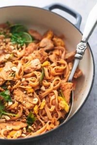 a skillet filled with noodles, meat and vegetables