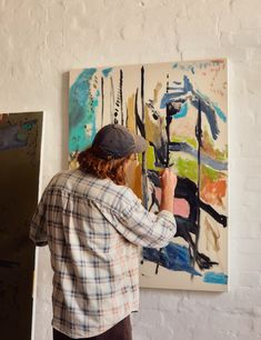 a man is painting on the wall with his hands