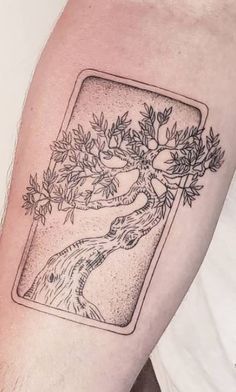 a man with a tattoo on his arm that has an image of a dog and tree