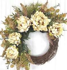 a wreath with white flowers and green leaves