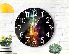 a large clock on the wall with numbers and lights in front of a potted plant