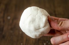 a person holding a ball of dough in their hand