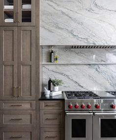 a kitchen with marble counter tops and stainless steel stove top oven, built - in wine rack