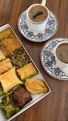 two plates with desserts on them next to a cup of coffee