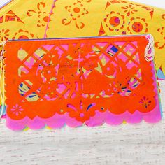 an orange and pink purse sitting on top of a wooden table