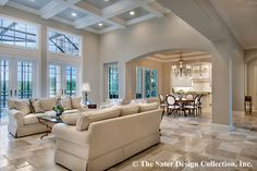 a large living room filled with furniture and lots of windows in front of the doors