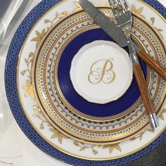 a blue and gold plate with two forks on it