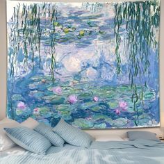 a large painting hanging on the wall above a bed with blue sheets and pillows in front of it