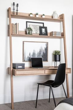 a wooden desk with a laptop on top of it and a chair next to it