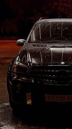 a black car parked in a parking lot at night