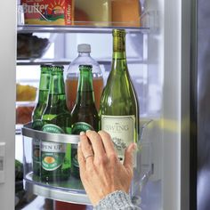 an older woman is looking in the refrigerator