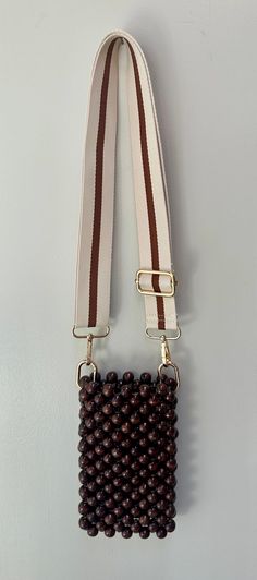 a brown and white beaded purse hanging on a wall