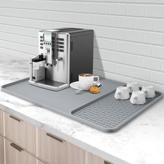 an espresso machine sitting on top of a counter next to some coffee cups