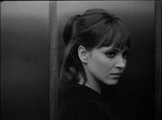 a black and white photo of a woman with her hair in a pony tail bun