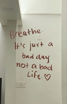 a white wall with writing on it and a light switch in the corner next to it