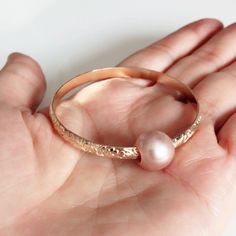 Adorable heirloom bangle for your princess is make with decorative floral pattern wire and genuine pink Edison pearl. Bangle is hand- formed, hammered and polished for a stunning texture and shine. It looks great worn alone or paired with other shell and charm bangles to create a chic, fun beachy look. Pink Edison pearl is 10-11 mm. Bangle is about 4mm wide and 1.5 in thickness. For engraving inside bangle: https://etsy.me/2H0W6C3 As you can see in the photos there are naturally occurring blemis Elegant Pink Pearl Bangle Bracelet, Pearl Bangle Jewelry Gift, Pearl Bangle Jewelry As Gift, Feminine Wedding Jewelry Bangle, Delicate Pink Pearl Bracelet For Wedding, Pearl Bangle As Gift, Pink Bangle Cuff Bracelet For Wedding, Pink Round Cuff Bracelet For Gifts, Bangle Jewelry For Bridesmaid Gift