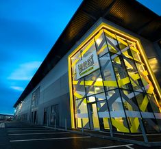 an exterior shot of a building with yellow and white lines on the side, lit up at night