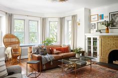 a living room filled with furniture and a fire place in front of a window next to a fireplace