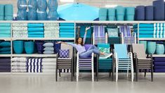 a woman is sitting at a table in front of stacks of blue and white plates