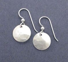 Handmade entirely in sterling silver 925, these small round earrings are fun to wear with casual everyday outfits. Dainty lightweight disc dangles are hand cut from sterling silver sheet metal then finished with a hammered dimple texture. Earring hooks are crafted in sterling silver wire. Earring Dimensions: Width - 1/2 inch across widest point of dangle (12mm) Drop Length - just over 1 inch from top of ear wire to bottom of dangle (26mm) Welcome to Seventh Willow: seventhwillow.etsy.com E266 Hypoallergenic Sterling Silver Round Disc Earrings, Silver Round Disc Earrings For Everyday Wear, Sterling Silver Round Disc Earrings For Everyday, Everyday Silver Round Disc Earrings, Everyday Sterling Silver Round Disc Earrings, Minimalist Sterling Silver Round Disc Earrings, Casual Everyday Outfits, 21st Wedding Anniversary, Wire Earring