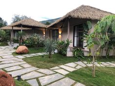 a house with grass thatched roofs and stone walkways