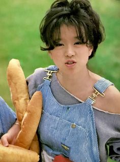 a woman holding a large loaf of bread