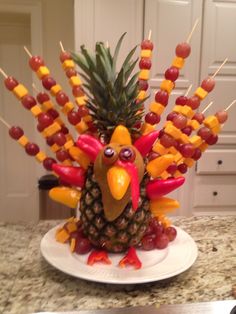 a turkey made out of pineapples, grapes and ketchup on a plate