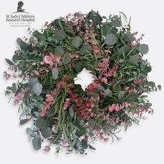 a wreath with pink flowers and green leaves