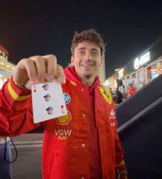 a man in red jacket holding up a card