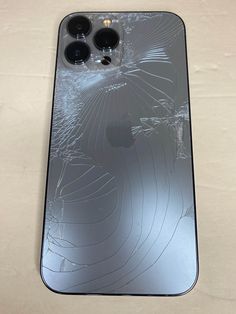 an iphone case that has been smashed and is sitting on a table with the screen cracked off