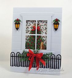 a white card with a red bow on it and a window in the back ground